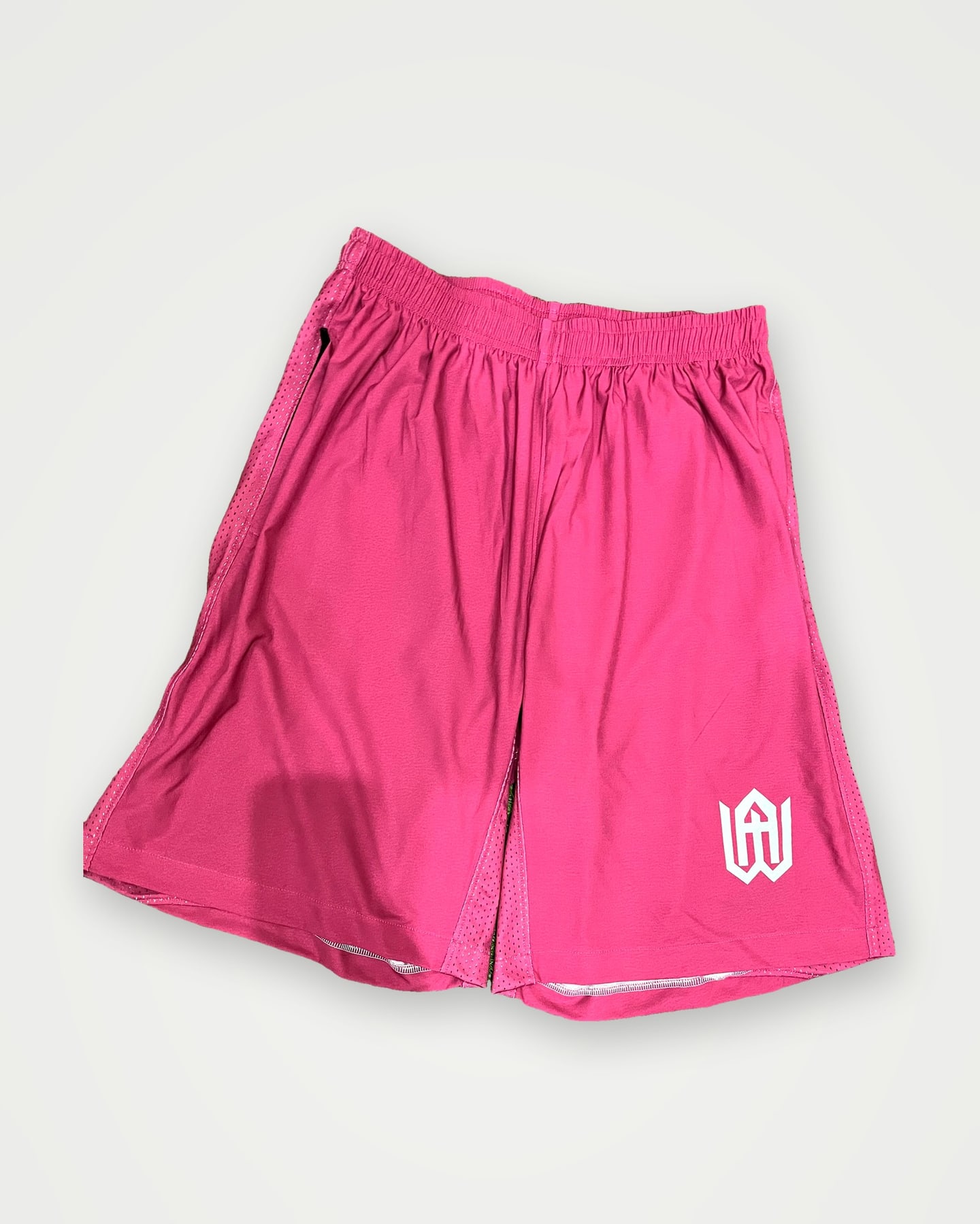 Pink athletic shorts with a small white logo