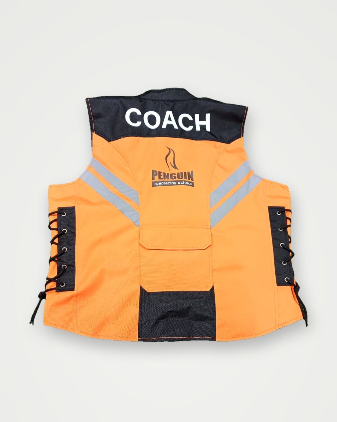 Back of an orange hi-vis vest with COACH lettering and a club badge