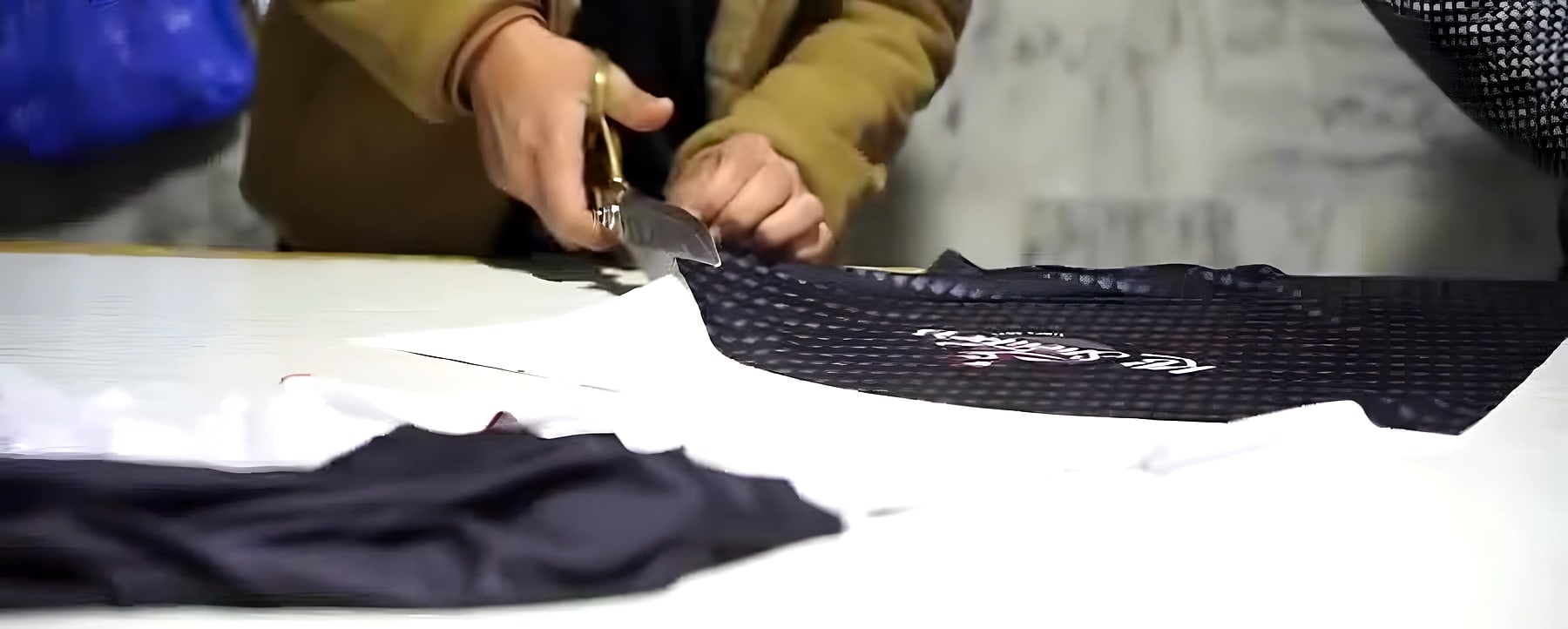 Cutting black mesh fabric to pattern with shears