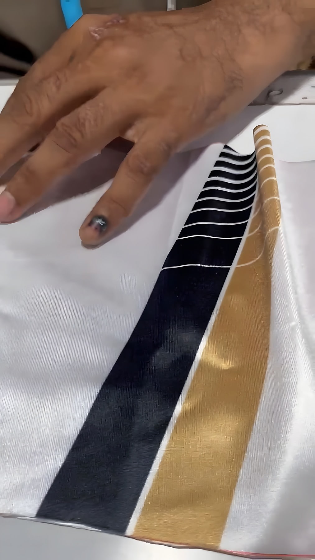 Sublimated navy and gold jersey panel being joined at the machine