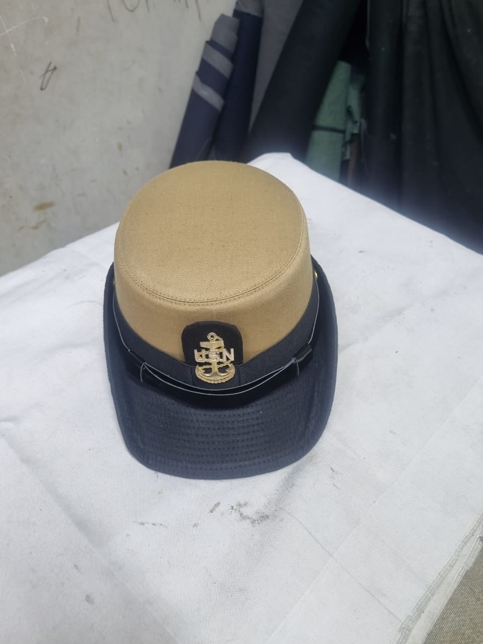 Khaki and navy peak cap with an embroidered badge