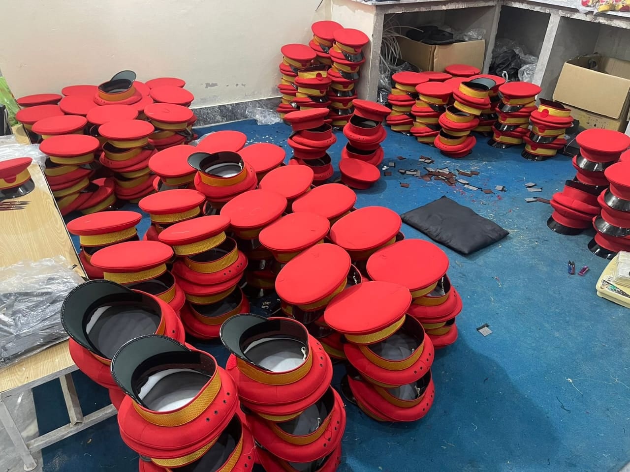 A large batch of red-top peak caps in the workshop