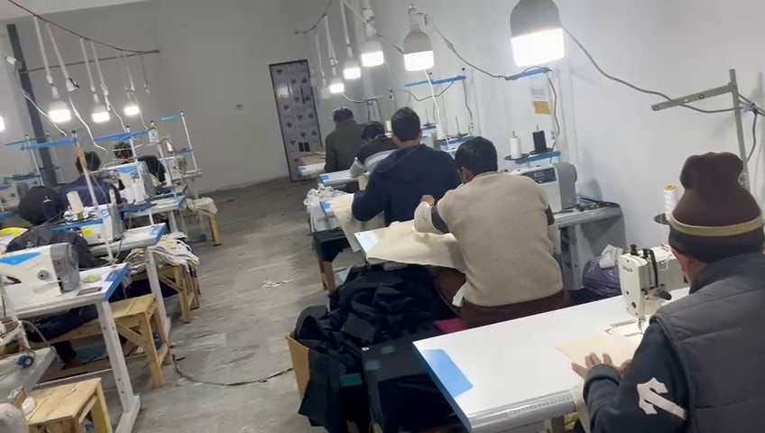 Operators working along a line of industrial sewing machines