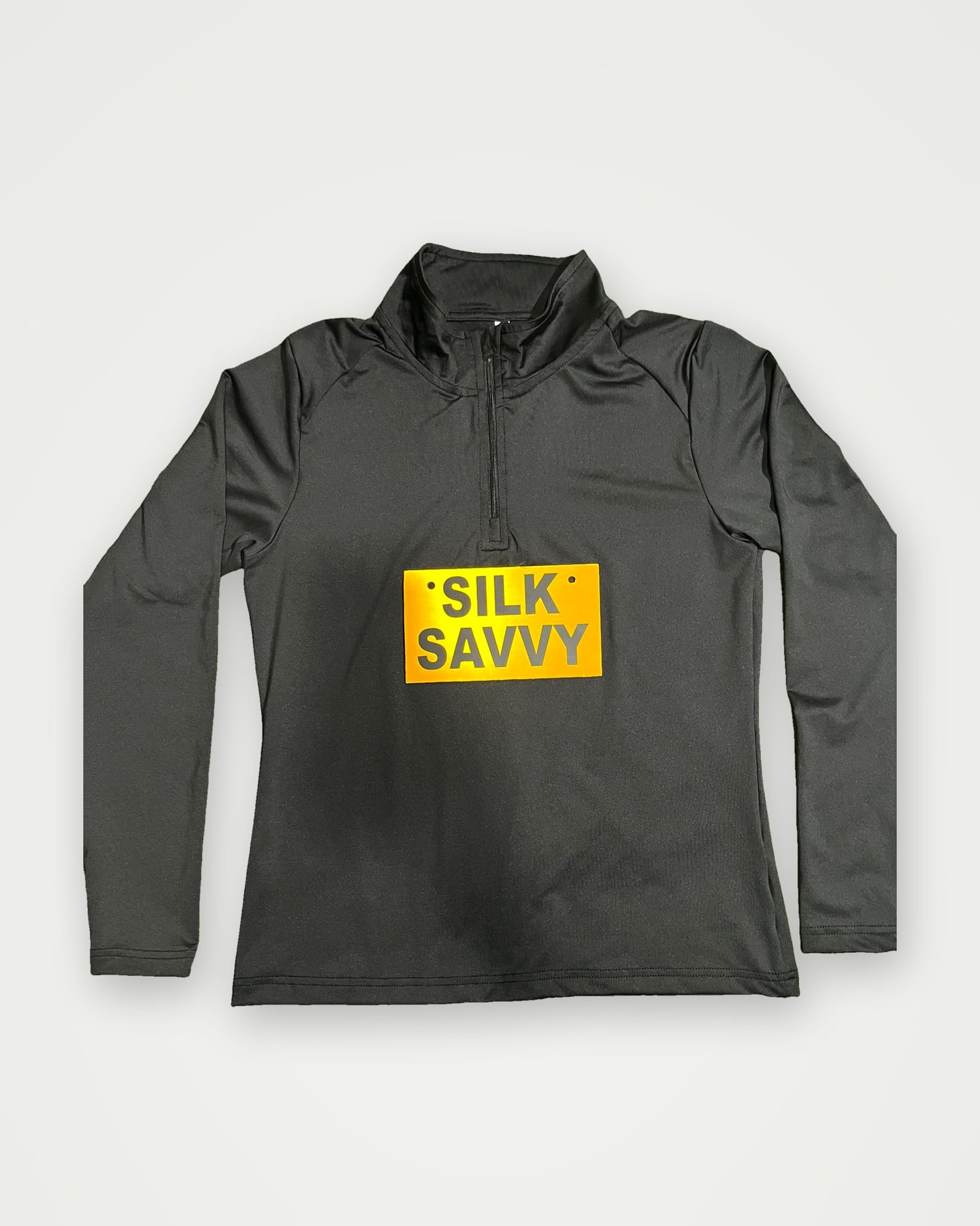 Black quarter-zip training top with an orange Silksavvy label